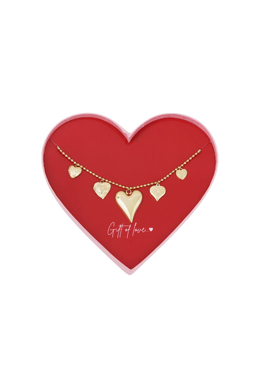 Gold-toned stainless steel necklace with five textured heart charms displayed in a red heart-shaped box inscribed with 'Gift of love..'