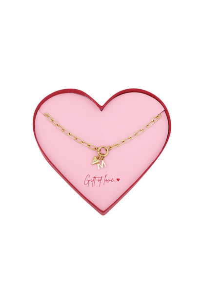 Gold-tone chunky link necklace with heart and letter M pendants presented in a pink heart-shaped box with ‘Gift of love’ inscription