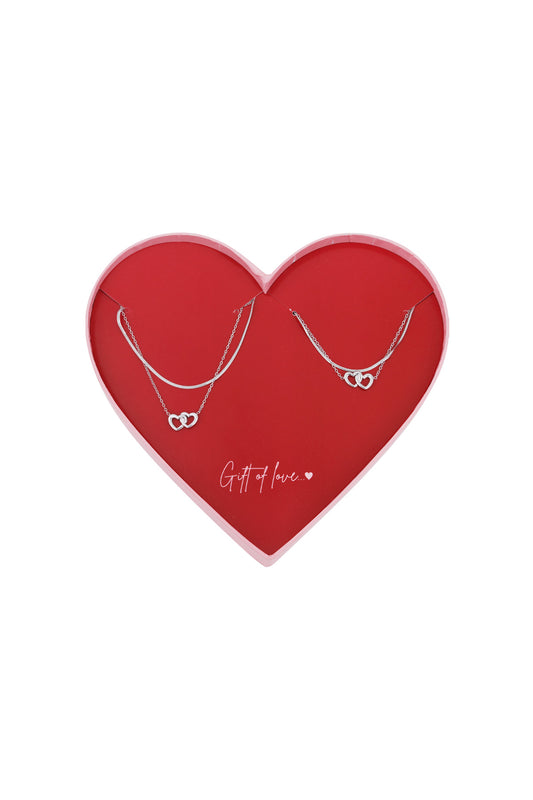 Silver layered necklace set with interlocking heart pendants displayed in a red heart-shaped box with 'Gift of love...' text
