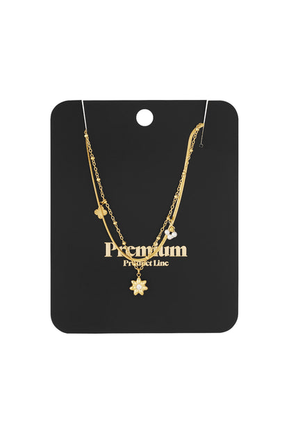 Gold layered flower charm necklace presented on a black premium product card