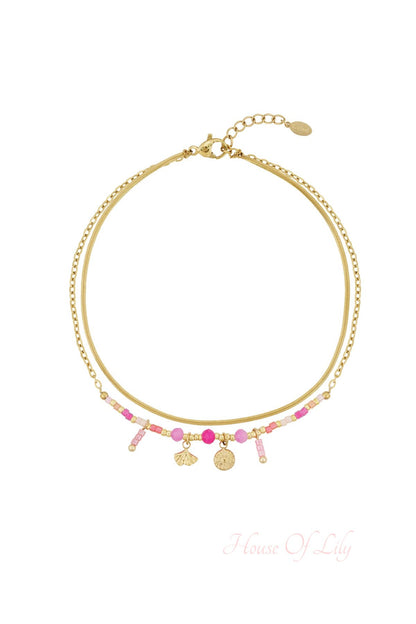 Pink and gold beaded double-layer anklet with shell and sun charms isolated on white background