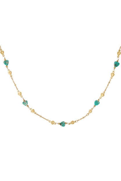 Close-up of gold-tone chain necklace with turquoise and gold heart-shaped beads on white background