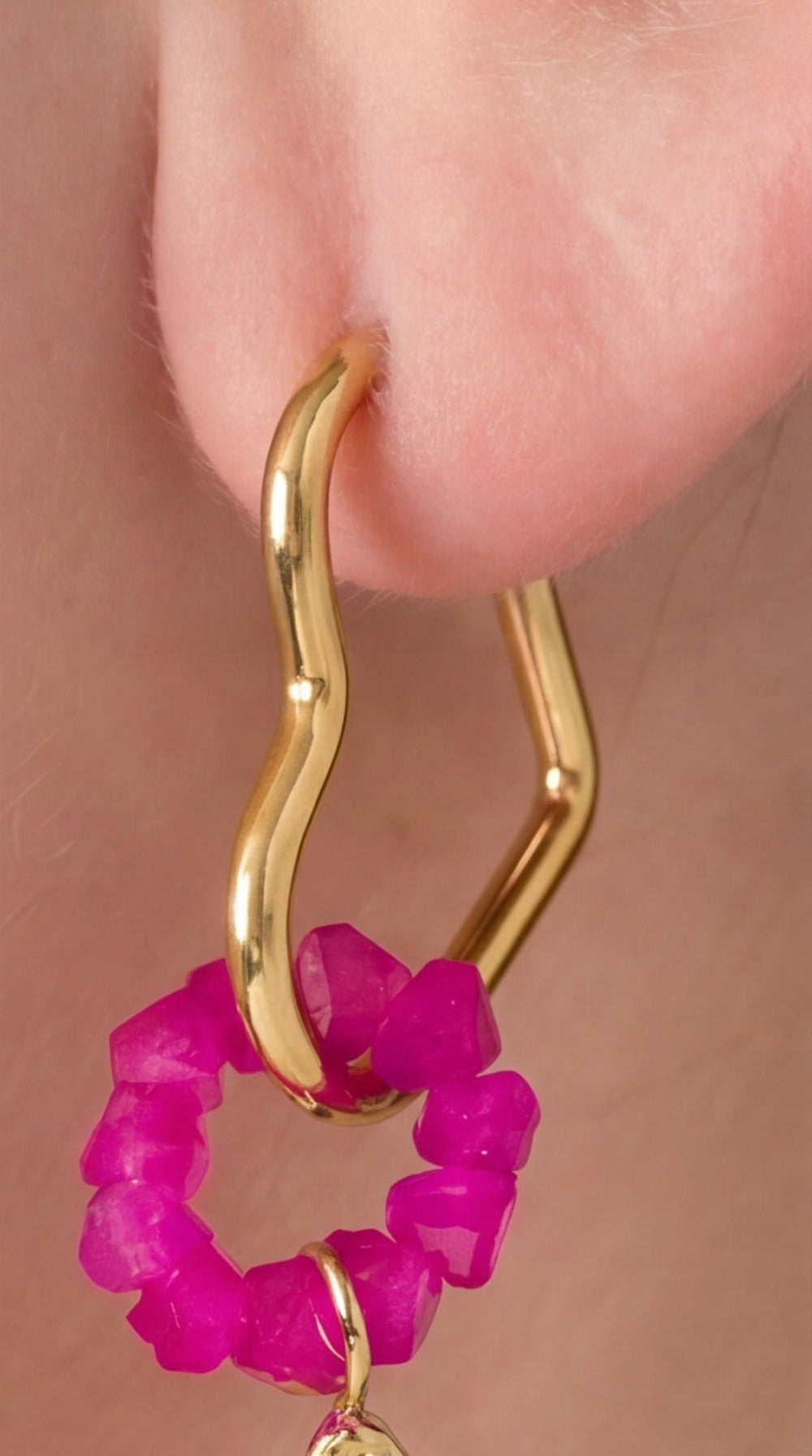 Shooting Star Drops: Gold-tone wavy hoop earrings featuring a dangling ring of small, faceted hot pink gemstone beads.