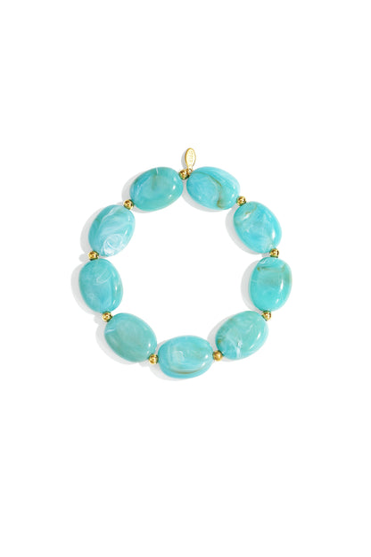 Close-up of a light turquoise swirled acrylic beaded bracelet with gold spacers on white background
