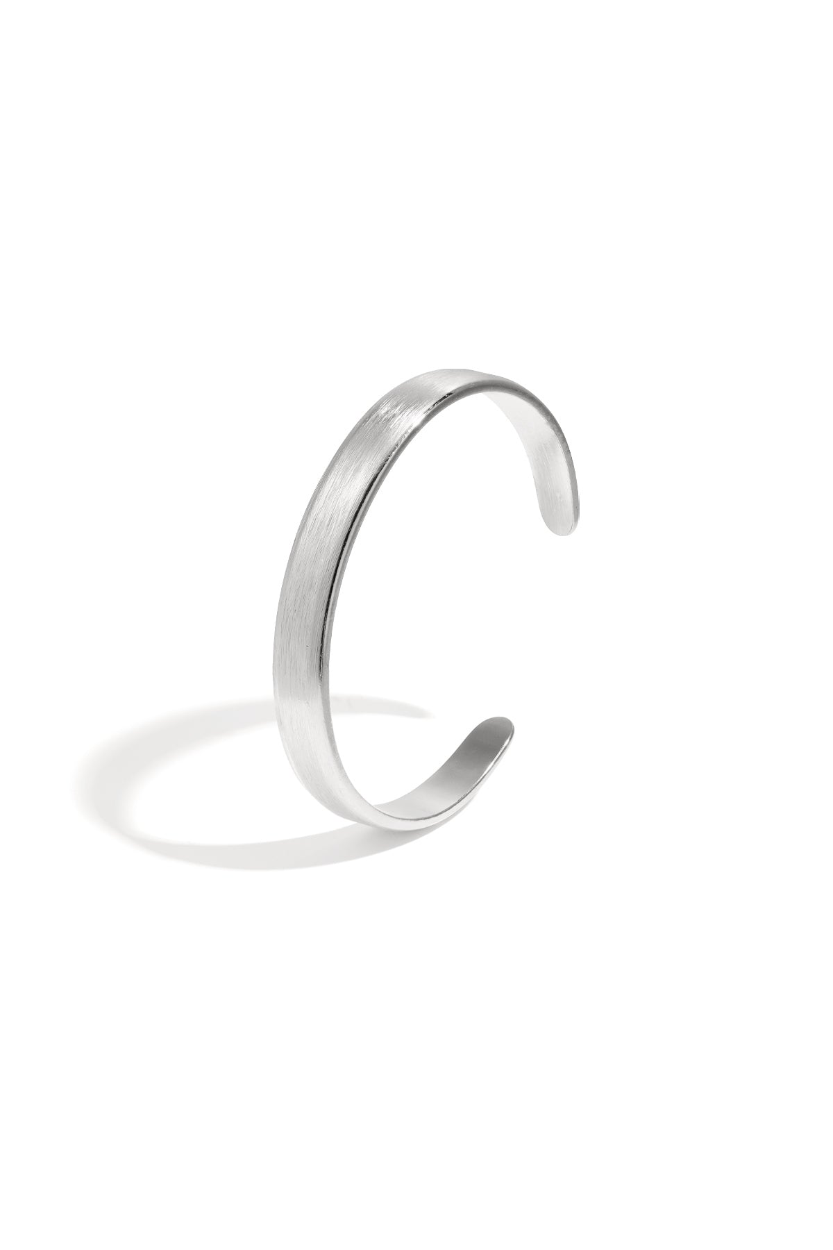 Silver brushed metal cuff bracelet with open curved design on white background