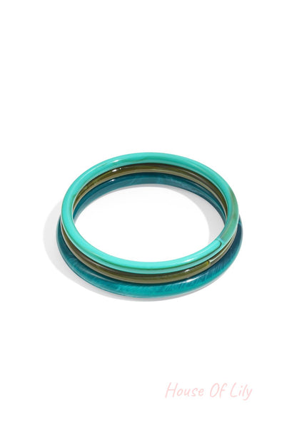 Stack of three blue and green resin bangles with glossy finish isolated on white