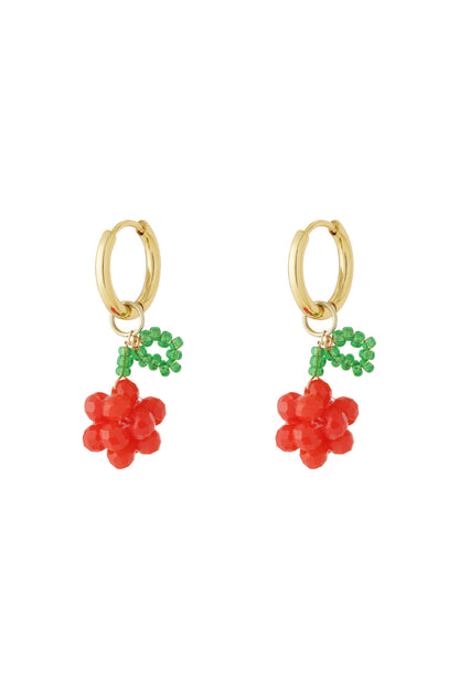 Pair of gold hoop drop earrings with red beaded cherry clusters and green bead leaves on a white background