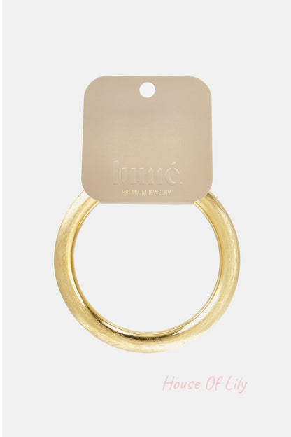 Minimalist round gold bangle with a brushed matte finish on a branded Lumé jewelry display card.