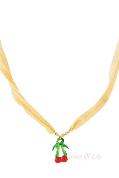 Yellow fabric cord necklace with a glass cherry pendant with bright red cherries and green stems