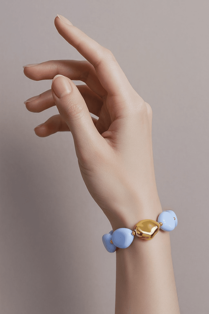 Chunky bracelet with smooth, periwinkle blue acrylic stones and a central, polished gold-tone organic nugget bead.