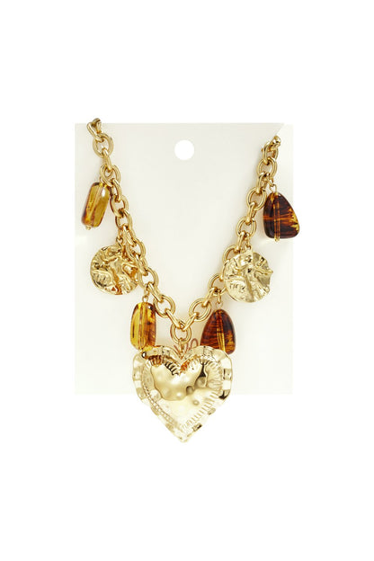 Gold-tone chain necklace with a large hammered heart pendant, mixed with gold discs and translucent amber-style charms.