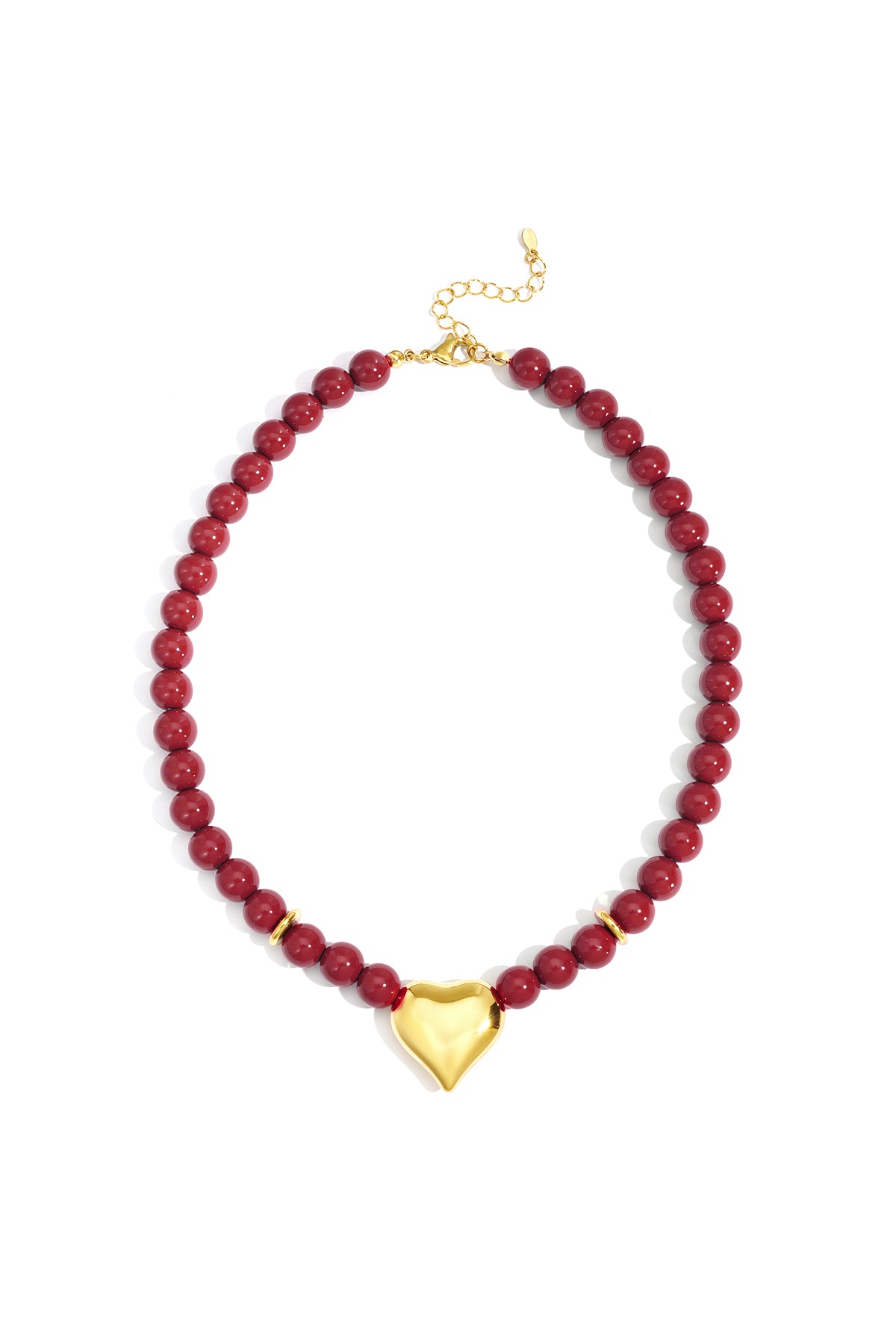 Close-up of glossy crimson red beaded necklace with shiny gold heart pendant and gold lobster clasp on white background