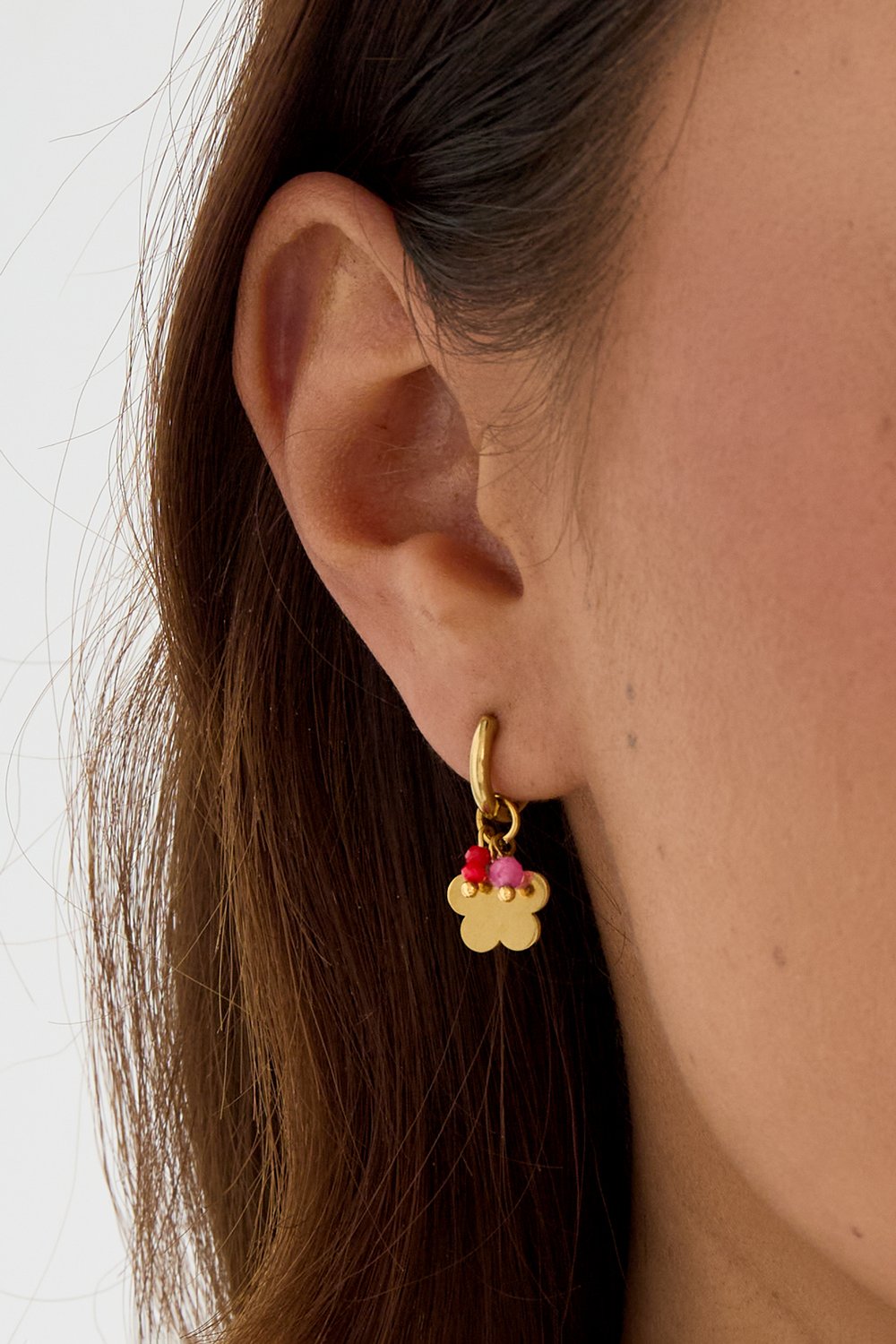 Gold Bloom Core hoop earring featuring a small flower charm with delicate pink and red stone accents.
