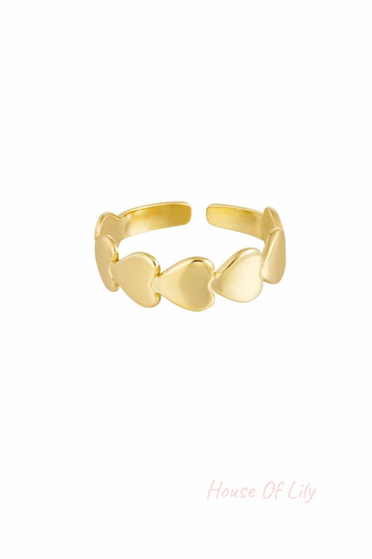 Adjustable gold-tone ring featuring linked heart shapes on a white background