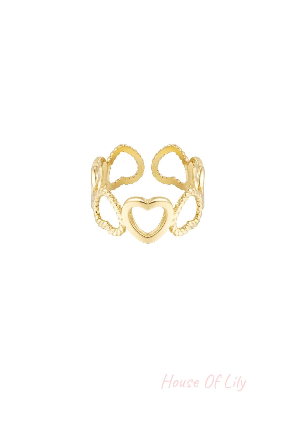 Close-up of gold heart link ring with open and twisted hearts on white background