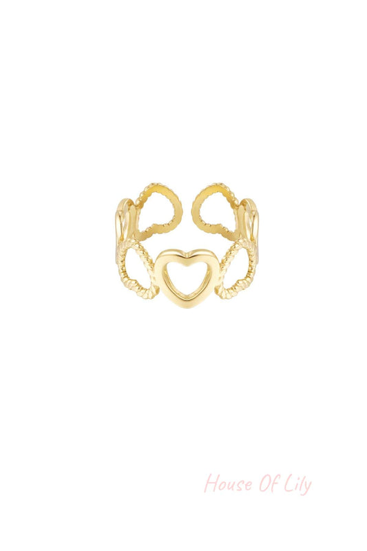 Close-up of gold heart link ring with open and twisted hearts on white background