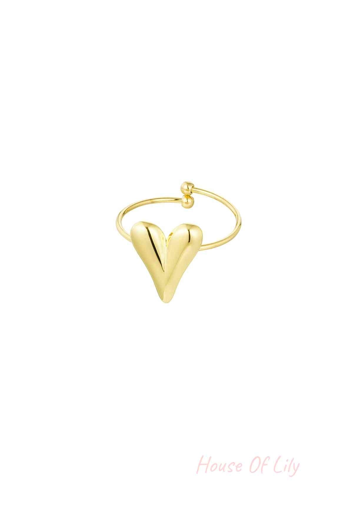 Gold heart-shaped adjustable statement ring on white background