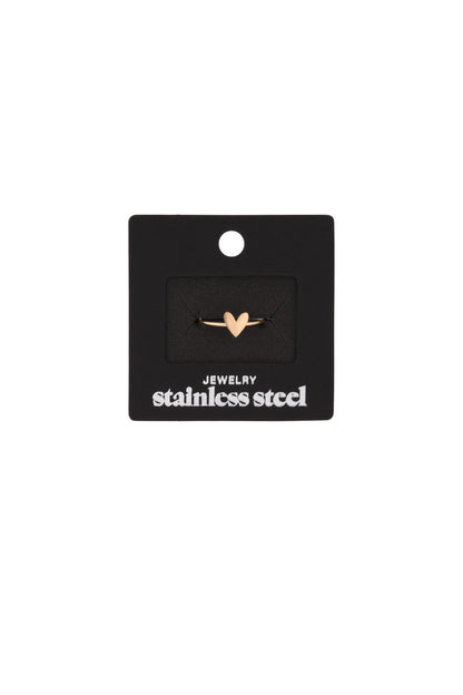 Gold heart minimalist ring displayed on black jewelry packaging card labeled stainless steel