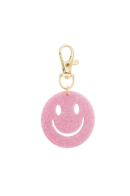 Light pink glitter smiley face keychain posed on white background