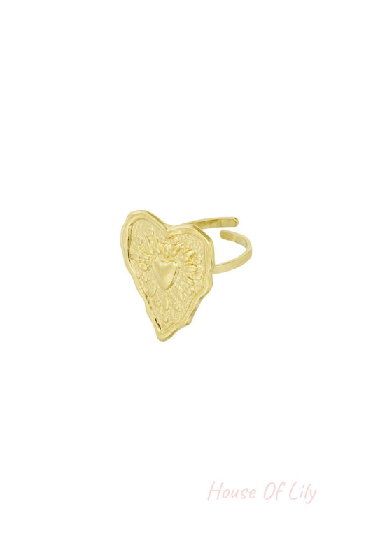Close-up of gold stainless steel ring with wrinkled heart design and embossed details on adjustable band