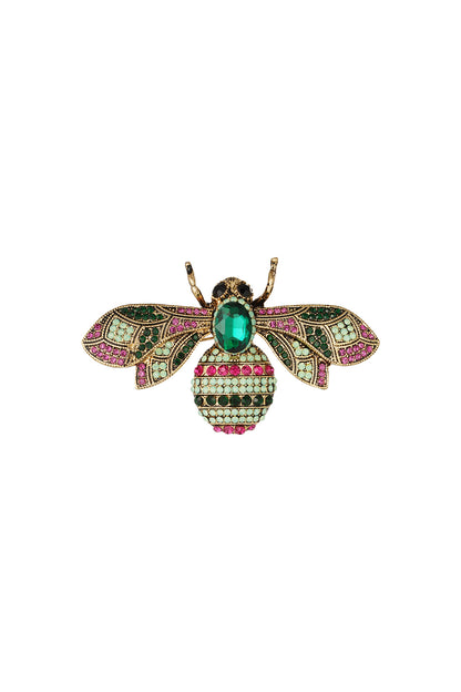 Close-up of a colorful bee brooch with green, pink, and seafoam rhinestones on an alloy base