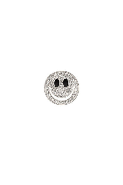Close-up of a silver-tone smiley face brooch adorned with clear crystals and black enamel eyes on a white background
