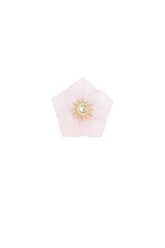 Close-up of pink flower-shaped statement ring with golden ornate center and clear crystal