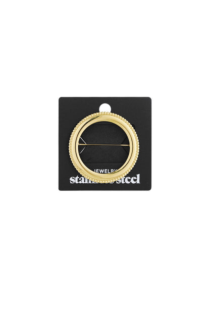 Gold circle brooch attached to black packaging card labeled stainless steel jewelry, highlighting secure pin fastening