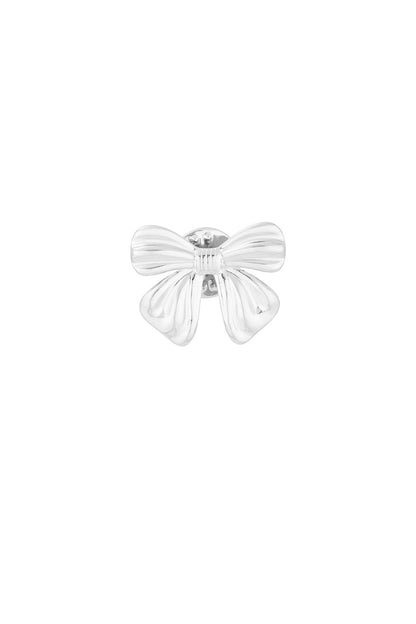 Close-up of polished silver bow-shaped brooch with smooth curves on white background