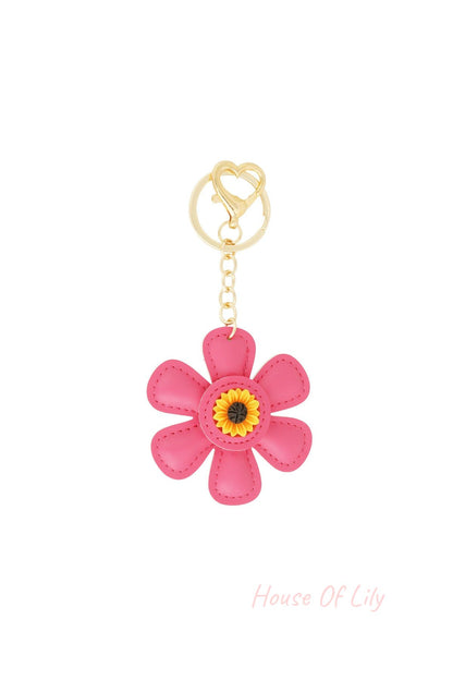 Pink faux leather floral keychain with sunflower center and gold heart clasp on white background