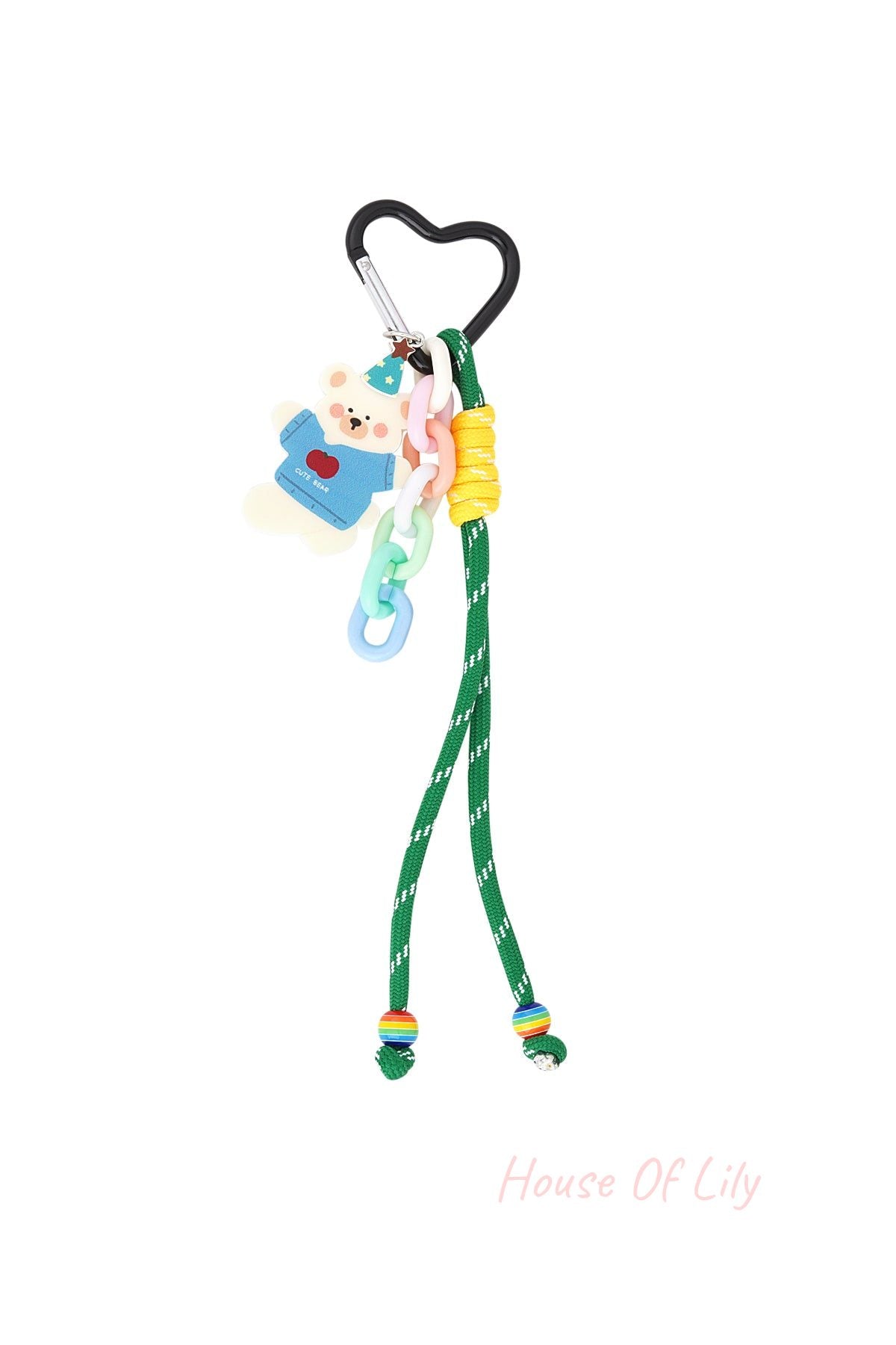 Heart-shaped black clip bag charm with a white bear wearing a blue party hat and sweater, pastel plastic chain links, green cord with yellow accent, and rainbow beads