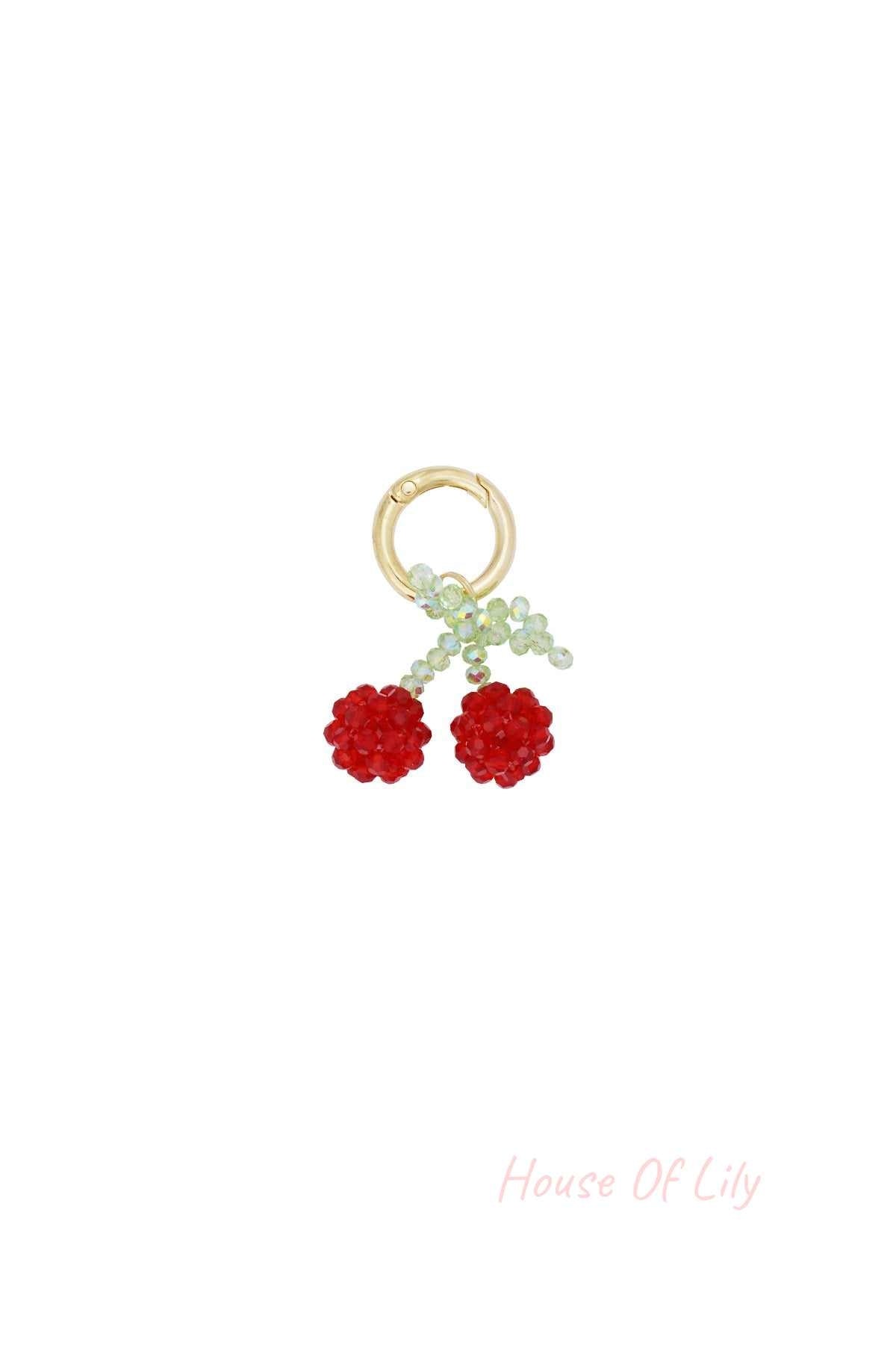Cherry bead bag charm with red and green beads on gold-tone clasp isolated on white background