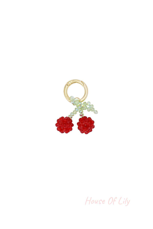 Cherry bead bag charm with red and green beads on gold-tone clasp isolated on white background