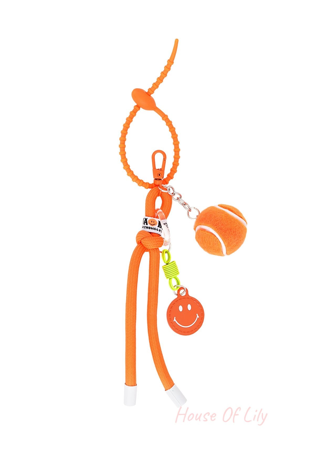 Vibrant orange tennis ball keychain with braided rope and smiley face charm on white background