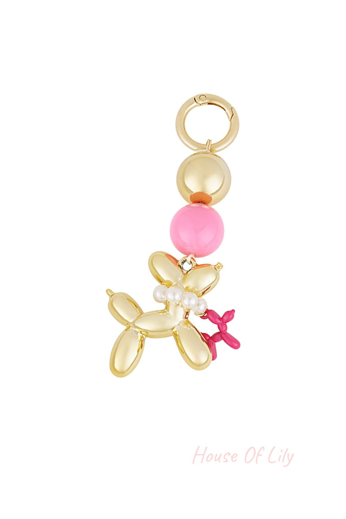 Close-up of a gold-tone balloon dog bag charm with pearl beads and pink accents against a white background