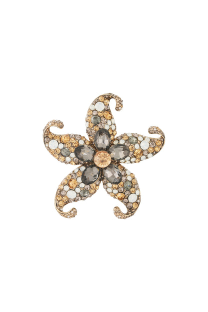 Close-up of a starfish-shaped floral brooch with champagne, smoky gray, and clear rhinestones on an alloy base