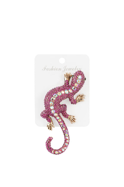 Fuchsia and iridescent crystal gecko brooch on a white fashion jewelry card