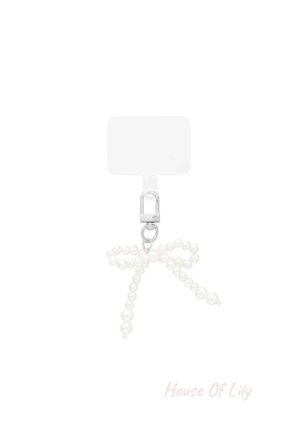 Pearl bow shaped bag charm with silver clasp on white background