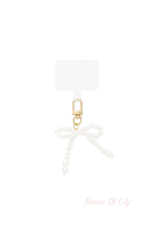Pearl bow shaped bag charm with golden clasp on white background