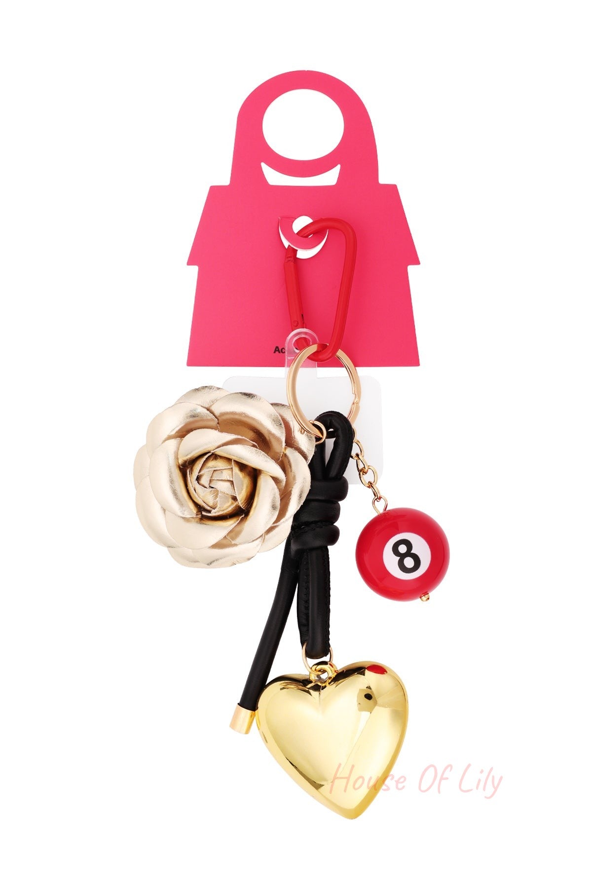 Product layout view of the bag charm hanging from red packaging card, displaying the gold rose, red 8-ball, glossy golden heart, and red clip
