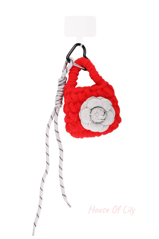 Red chunky knit mini purse bag charm with grey felt flower and striped white laces clipped on black carabiner