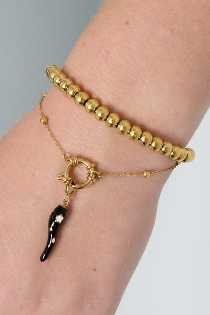 Close-up of gold-toned minimalist beaded bracelet worn alongside a gold beaded bracelet on wrist