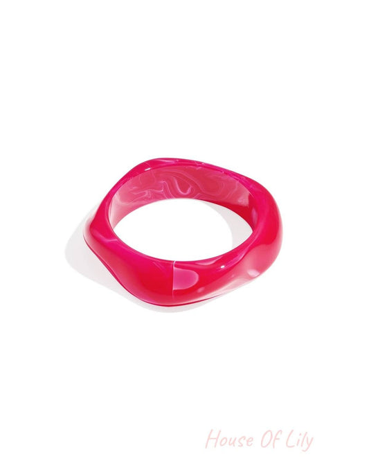 Single bright pink marbled acrylic wavy square bangle on a white background