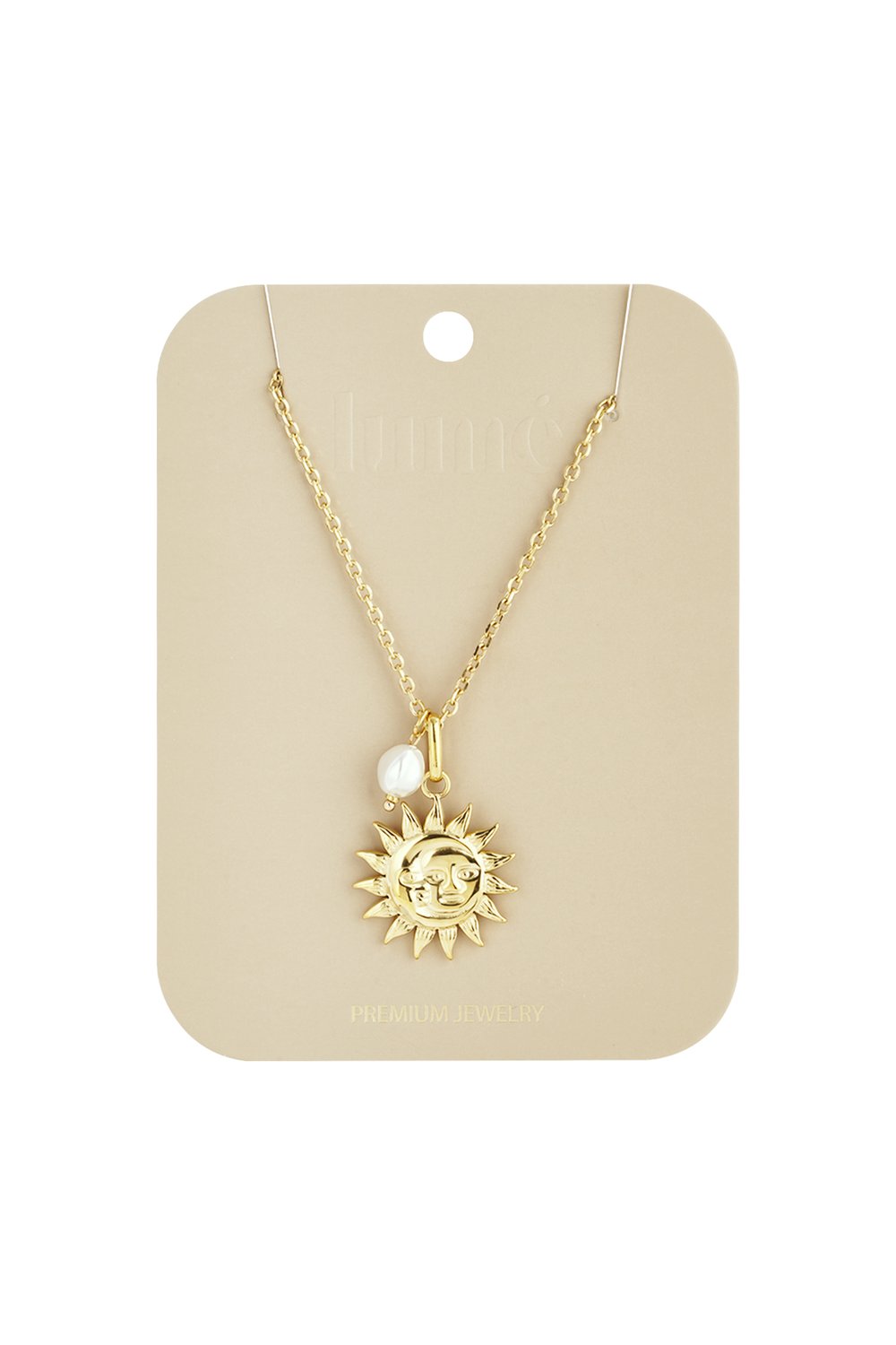 Gold sun face pendant necklace on a chain with a small white baroque pearl charm on a branded beige display card.
