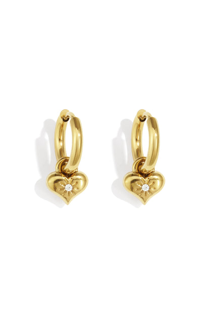 Pair of golden hoop earrings with heart-shaped charms featuring a central rhinestone in a sunburst design on white background