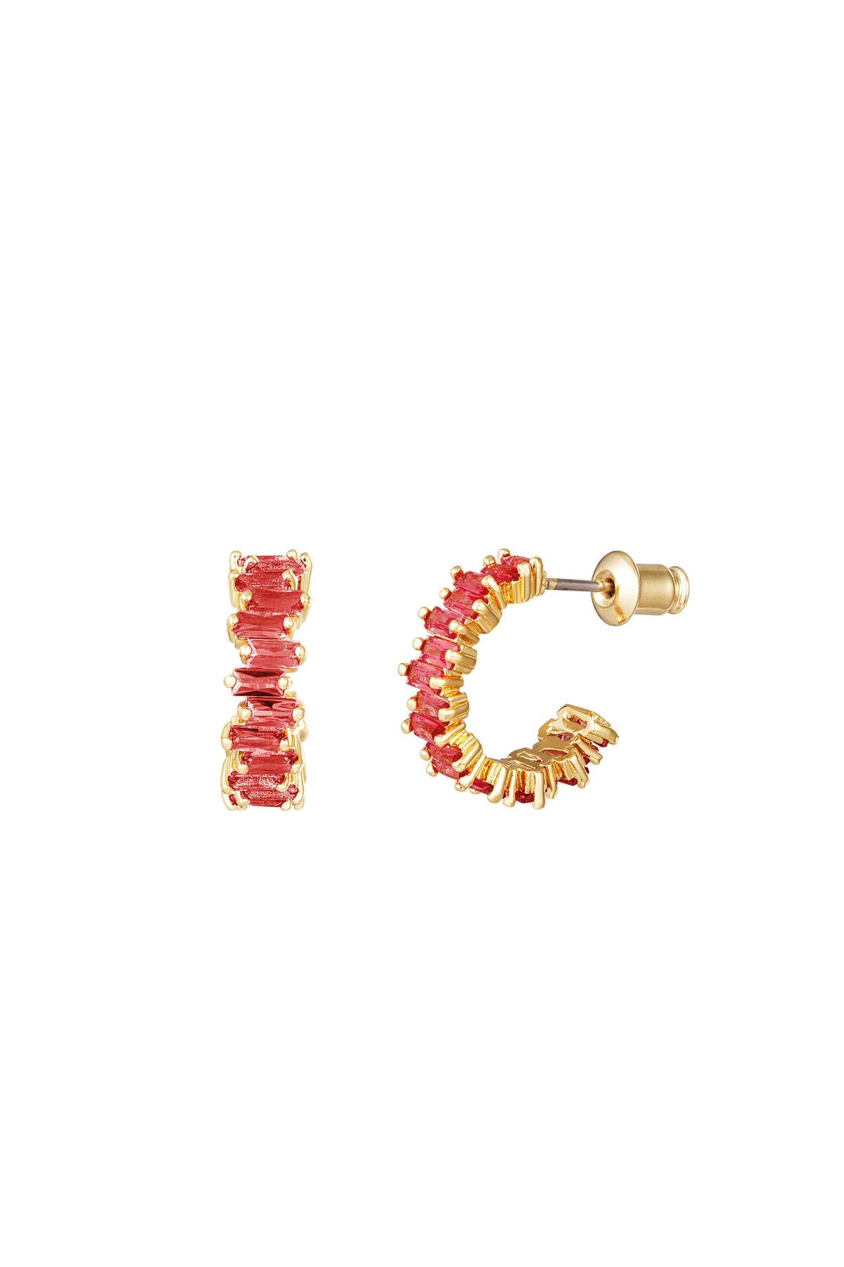 Gold-tone semi-circle hoop earrings adorned with red baguette crystals displayed on a white background