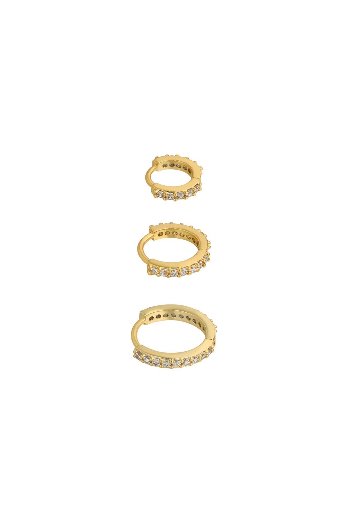 Three gold-tone hoop earrings lined with sparkling clear stones in small, medium, and large sizes on white background