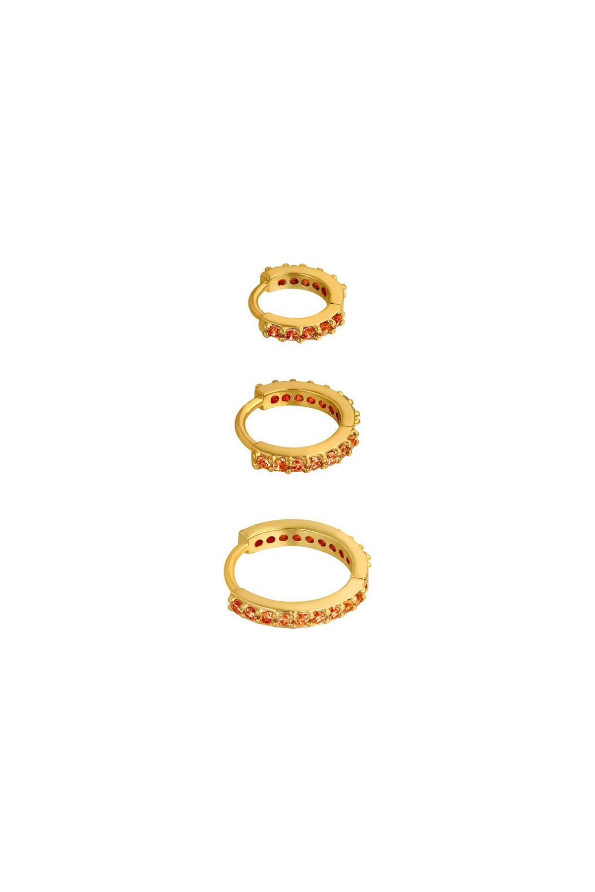 Three gold-tone hoop earrings lined with orange stones in small, medium, and large sizes on white background