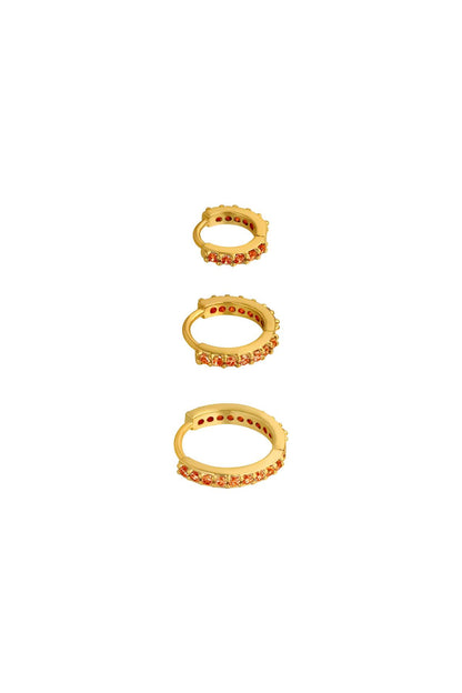 Three gold-tone hoop earrings lined with orange stones in small, medium, and large sizes on white background