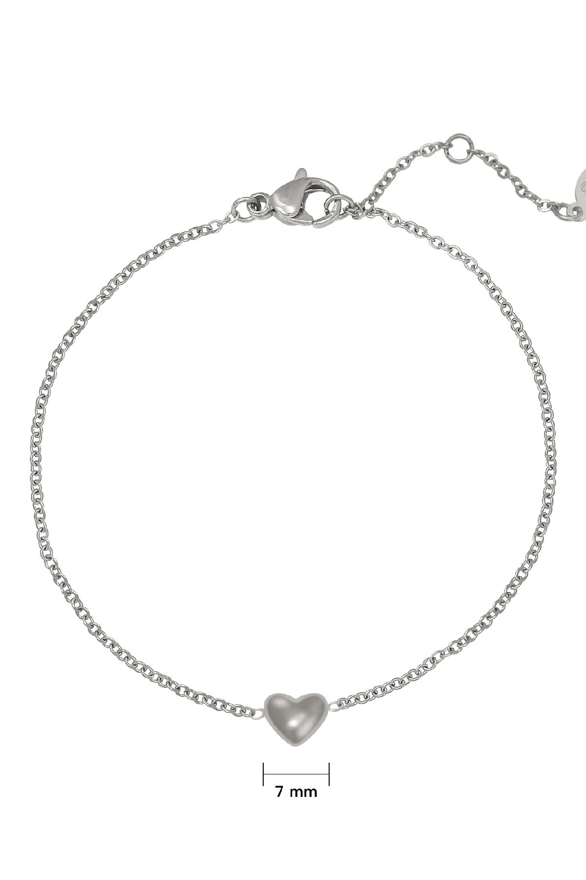 Close-up of silver chain bracelet with 7mm heart charm and lobster clasp on white background